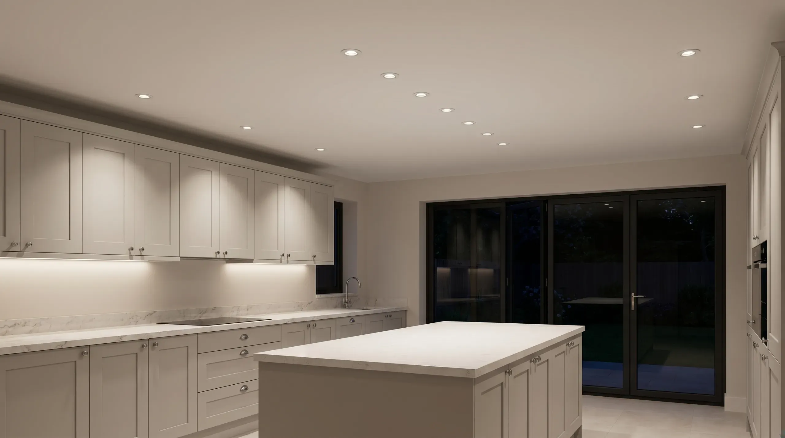 Two parallel rows of recessed LED downlights illuminating a modern white kitchen with island and worktop, casting even light across the floor and worktops without harsh hotspots