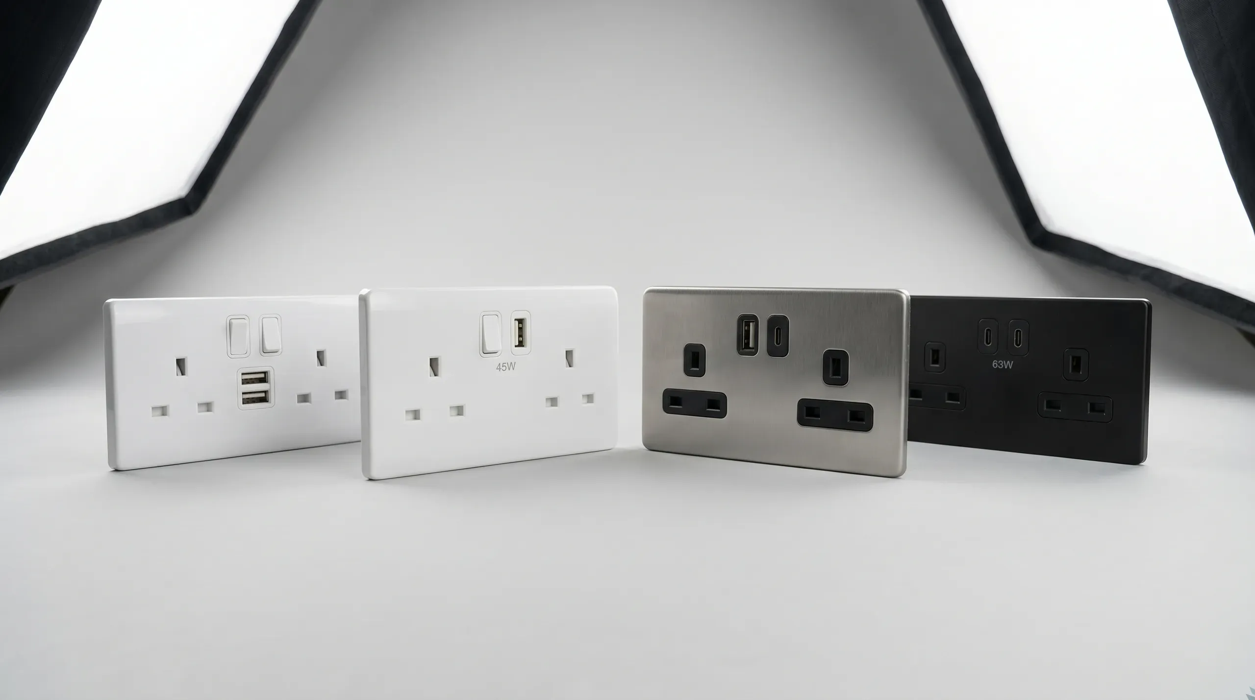Selection of UK USB charging sockets in white plastic and brushed steel finishes, showing single USB-A, dual USB-A, USB-A plus USB-C combo, and dual USB-C variants side by side